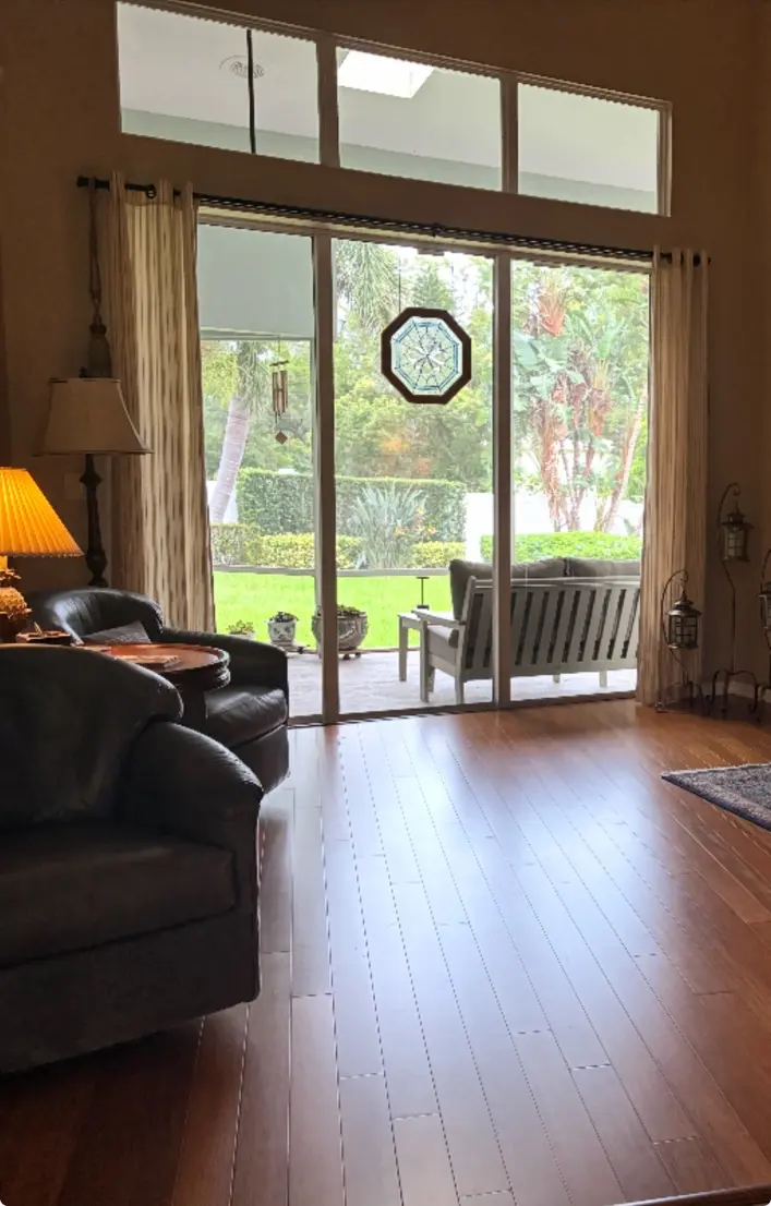 Finished hardwood flooring in a sunlit living room with patio view